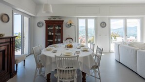 A dining area with a round table, white chairs, and a view of the outdoors. - LA TERRAZZA - Between sky and sea, silence speaks of beauty (Rapallo)