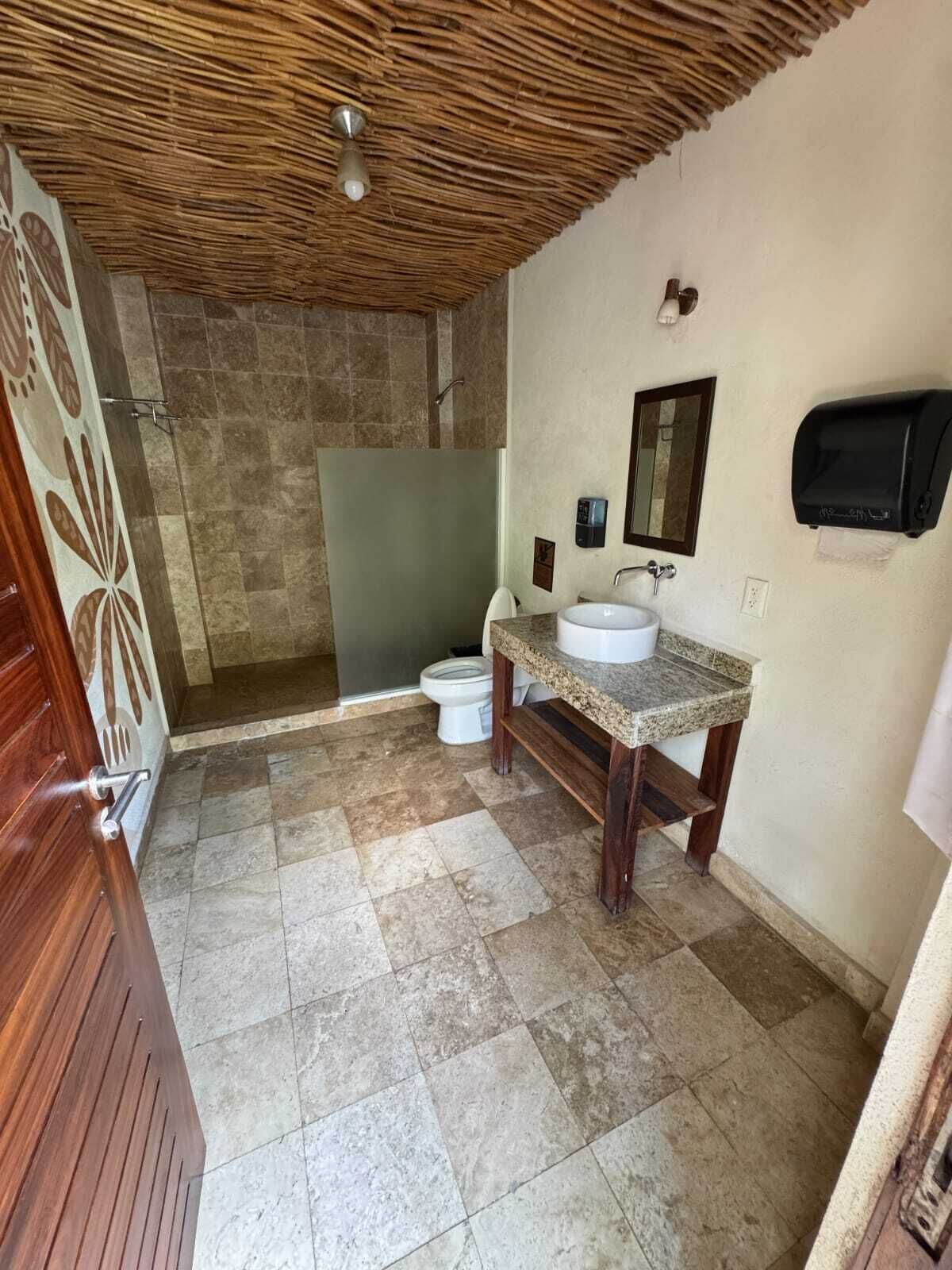 A bathroom with a shower, toilet, and sink.