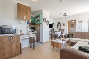 A compact living space with a kitchenette, dining area, and seating area. - Sochoro Sun Mountain Hospitality Country House with Mountain View, Wi-Fi, and Air Conditioning (Επισκοπή)