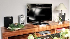 Eine Holz-Unterhaltungsanlage mit Flachbildfernseher, Lautsprechern und Fernbedienung.