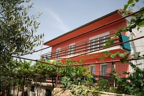 A two-story building with a red facade and balconies. - Apartments Erla (16014-A2) - Banjole (Banjole)