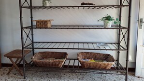 A metal shelving unit with baskets and a potted plant. - Torre Plaza 4. A cozy apartment in Boiro, beaches and terraces. (boiro)
