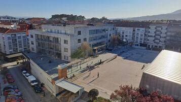 Un edificio de varios pisos con patio, estacionamiento y vista del barrio circundante.