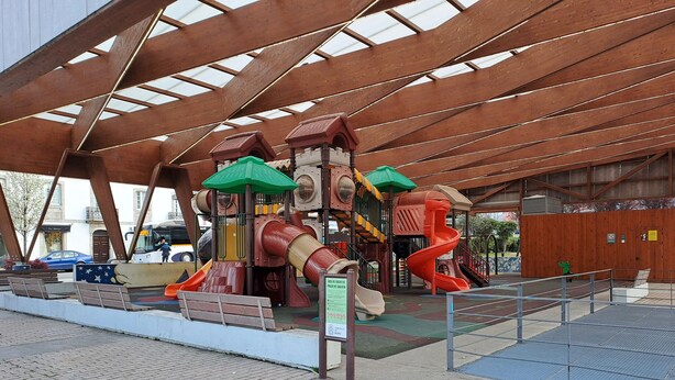 A playground with slides and climbing structures under a large metal roof. - Torre Plaza 4. A cozy apartment in Boiro, beaches and terraces. (boiro)