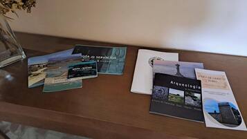 A wooden table with brochures and a glass vase.