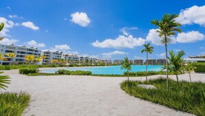 Un resort con piscina, palme e un cielo azzurro limpido.