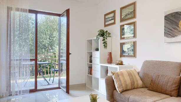 A living room with a sofa, a coffee table, a bookshelf, and a sliding glass door leading to a balcony. - House Anka (16038-K1) - Medulin (Medulin)