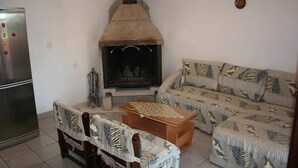 Un salon avec une cheminée, un canapé, une table basse et un réfrigérateur.