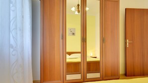 Une chambre à coucher avec une armoire en bois, un lit et une table de chevet.