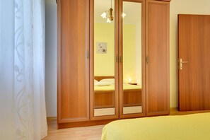 A bedroom with a wooden wardrobe, a bed, and a nightstand. - Apartments Danilo (16068-A1) - Medulin (Medulin)