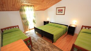 Una stanza con due letti singoli, un tavolo in legno e un tappeto decorato.