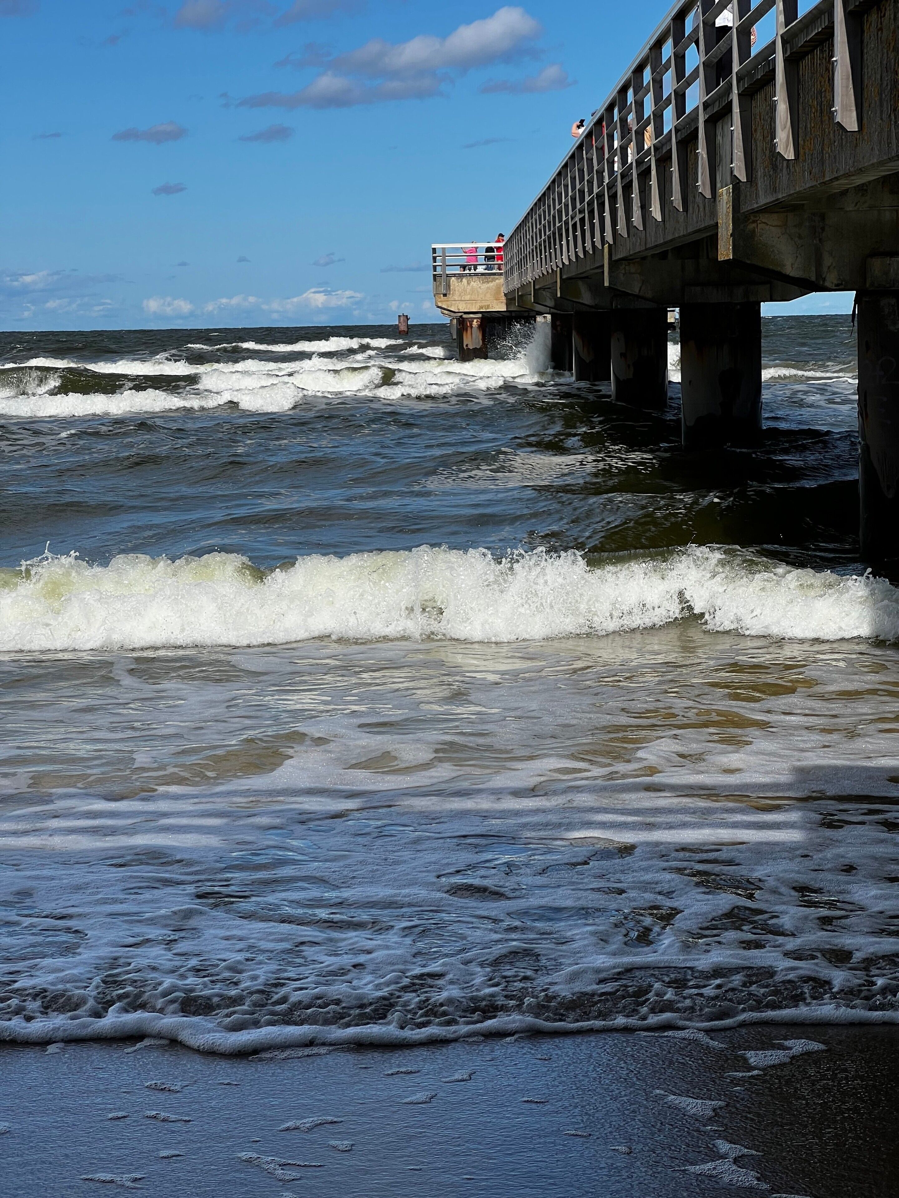 Une jetée qui s’avance dans l’océan, où les vagues viennent s’écraser.