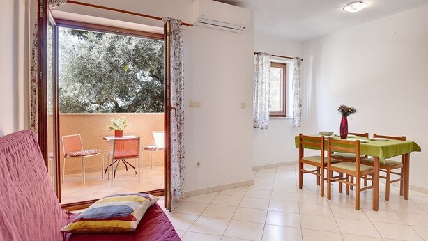 A room with a sofa, a dining table with chairs, a balcony with chairs, and a window. - Apartments Ulika (16031-A4) - Medulin (Medulin)
