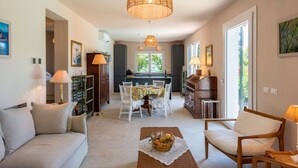 A modern interior with a dining area, sofa, and a large window. - CASA LIMONAIA - Where the sea speaks to you and silence embraces your soul (Rapallo)