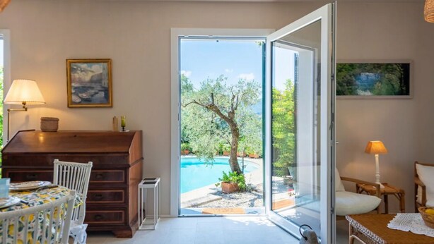 A room with a view of an outdoor swimming pool, a wooden desk, a dining table, and a chair. - CASA LIMONAIA - Where the sea speaks to you and silence embraces your soul (Rapallo)