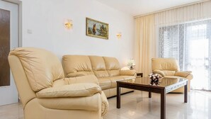 Una sala de estar con un sofá color beige, una mesa de centro y un cuadro en la pared.