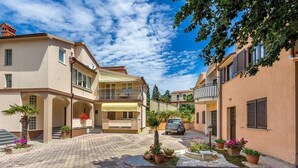 A residential street with houses, a car, and potted plants. - Apartments Nevija (16066-A2) - Medulin (Medulin)
