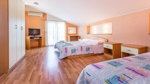 A bedroom with two beds, a TV, a desk, and a wardrobe. - Apartments Nevija (16066-A3) - Medulin (Medulin)