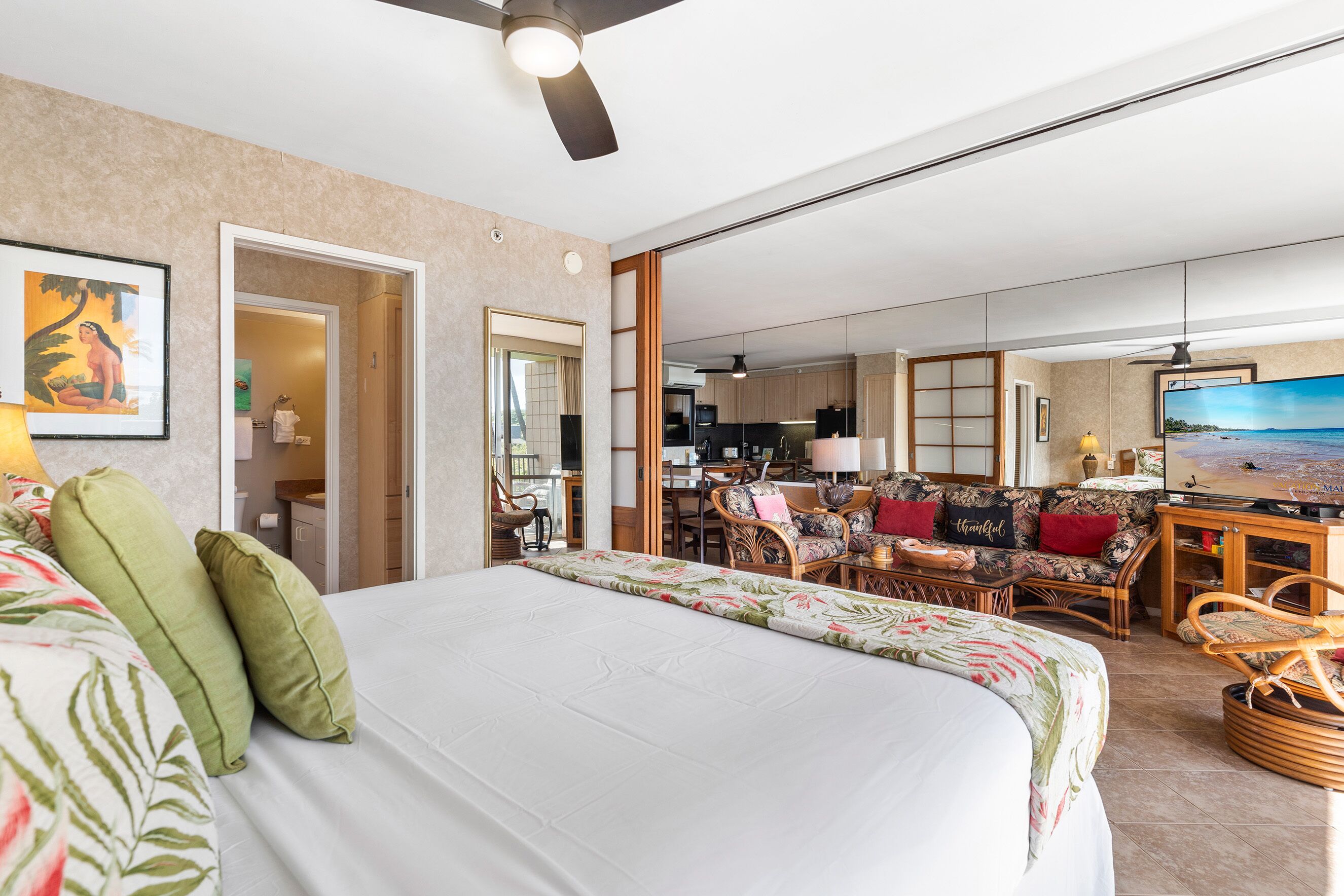 Une chambre d’hôtel avec un grand lit, un canapé, un coin repas et une télévision.