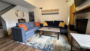 Una sala de estar con sofá, mesa de centro y chimenea.
