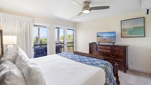 A bedroom with a bed, a dresser, a ceiling fan, and a view through the door. - Maui Hill (Kihei)