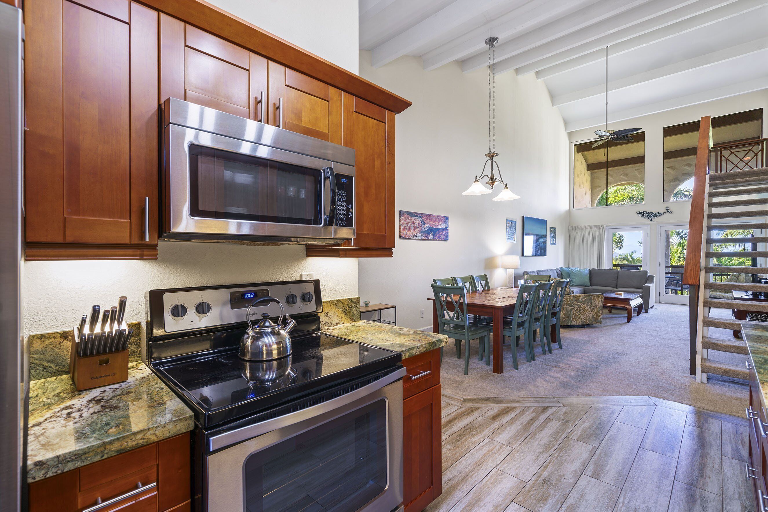 A kitchen with wooden cabinets, stainless steel appliances, and a granite countertop.