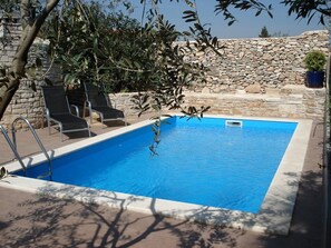 A rectangular swimming pool with a stone wall in the background. - Apartments Christa (16127-A4) - Krnica (Pula) (Krnica (Pula))