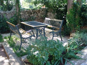 An outdoor seating area with a stone wall and greenery. - Apartments Christa (16127-A4) - Krnica (Pula) (Krnica (Pula))