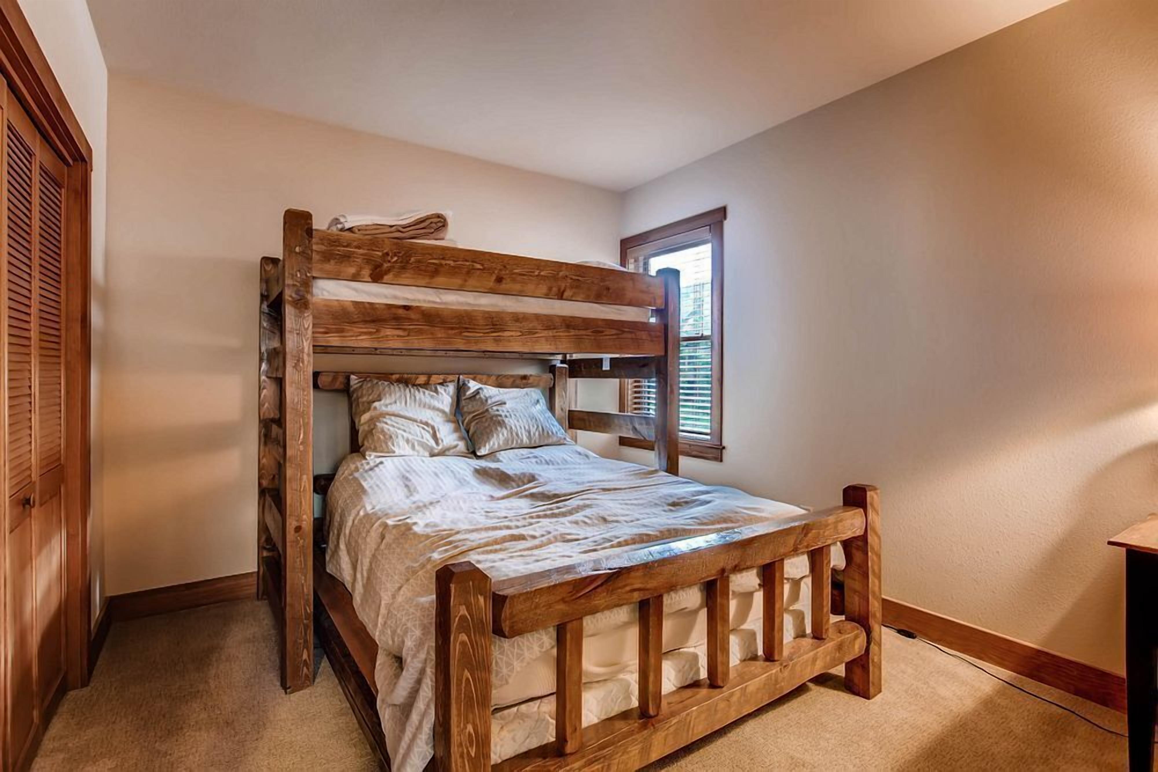 Un lit superposé avec une structure en bois et un matelas blanc.