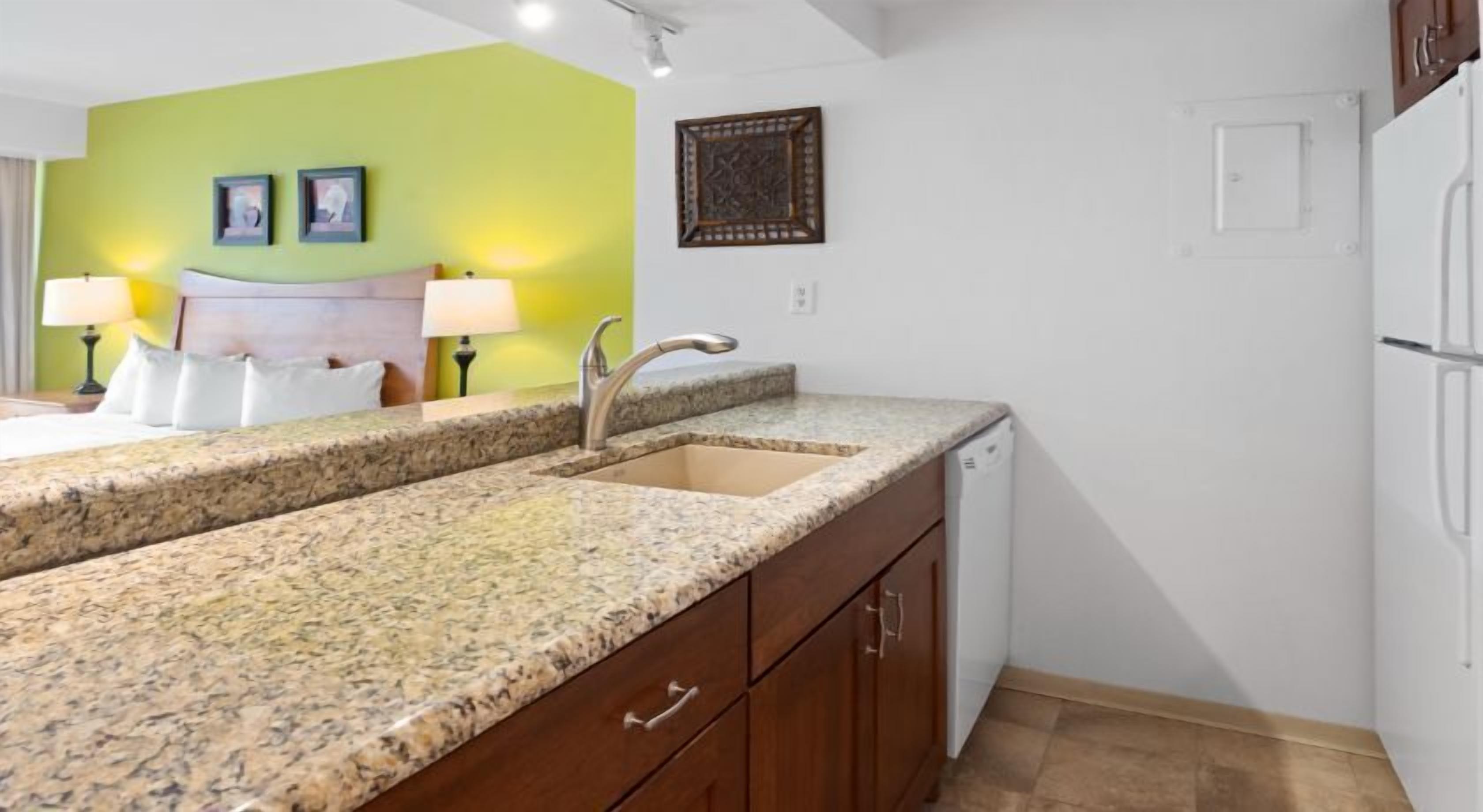 A kitchen with granite countertops, a sink, and wooden cabinets.