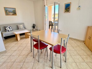 Ein Essbereich mit Tisch, Stühlen, einer Couch und einer Bank.
