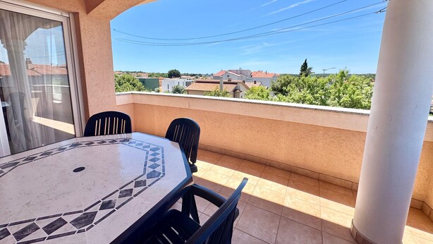 A balcony with a tiled table and chairs, a view of houses, and a clear sky. - Apartments Cukon (16136-A7) - Medulin (Medulin)