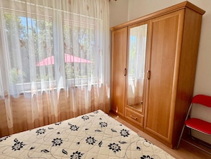 A bedroom with a bed, a wardrobe, a chair, and a window with curtains. - Apartments Cukon (16136-A9) - Medulin (Medulin)