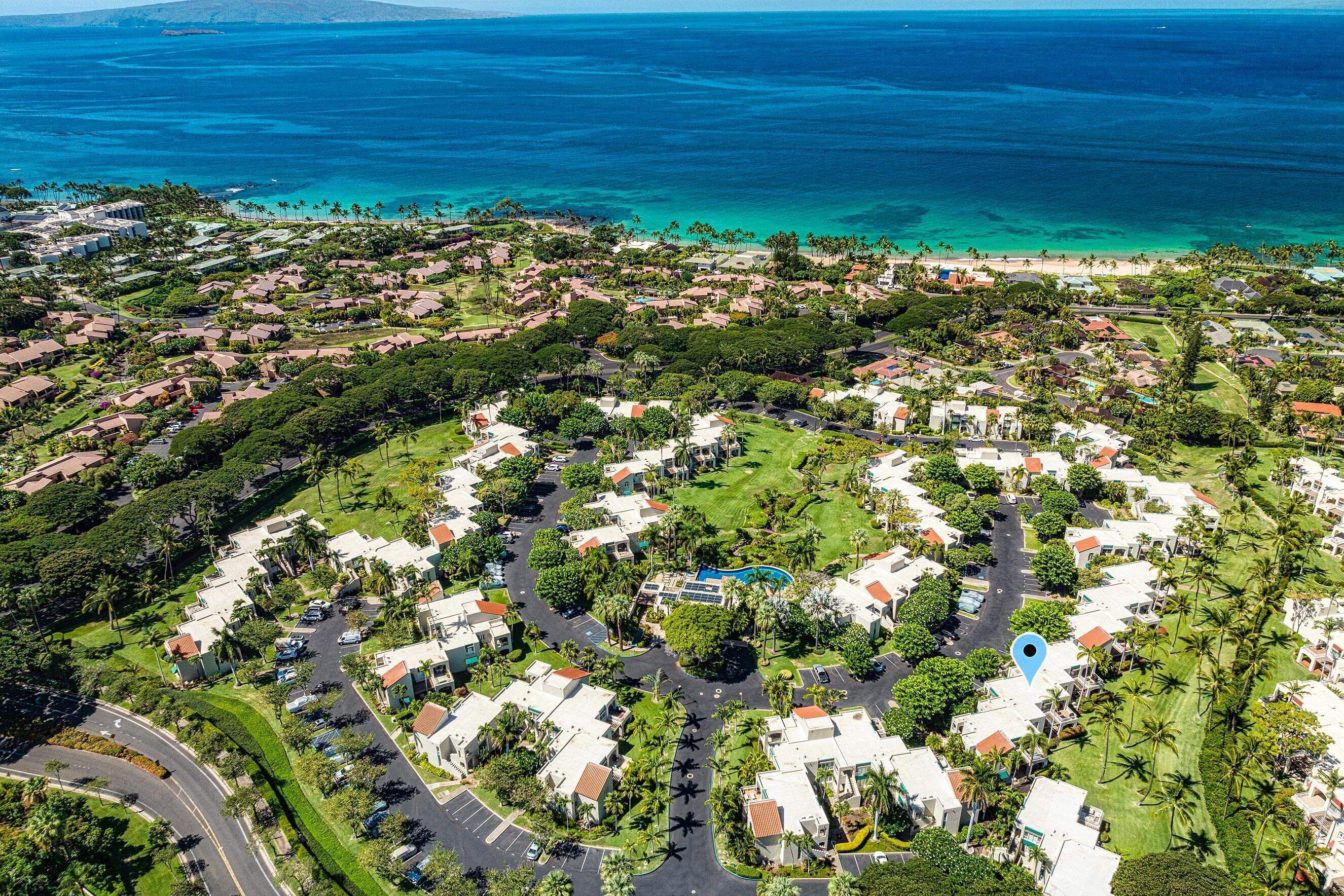Zona residencial con casas, calles y una playa al fondo.