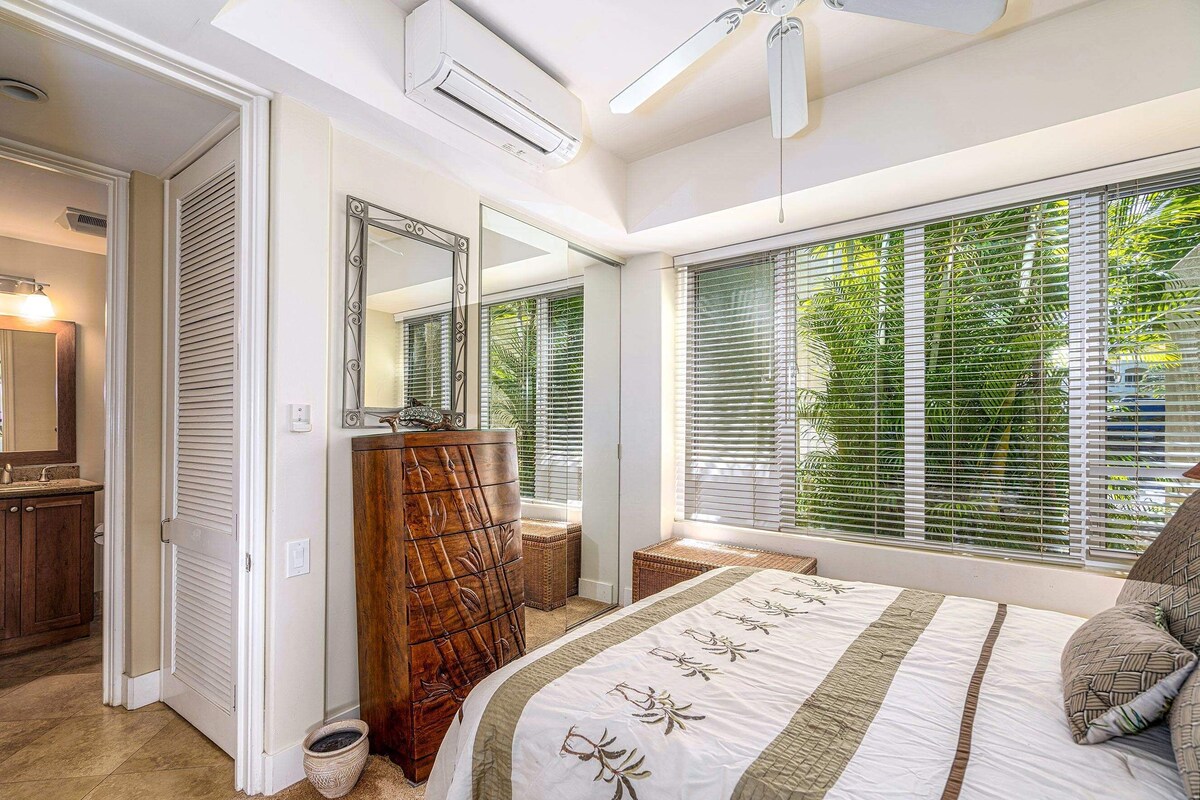 A bedroom with a bed, a dresser, a mirror, and a window with blinds.
