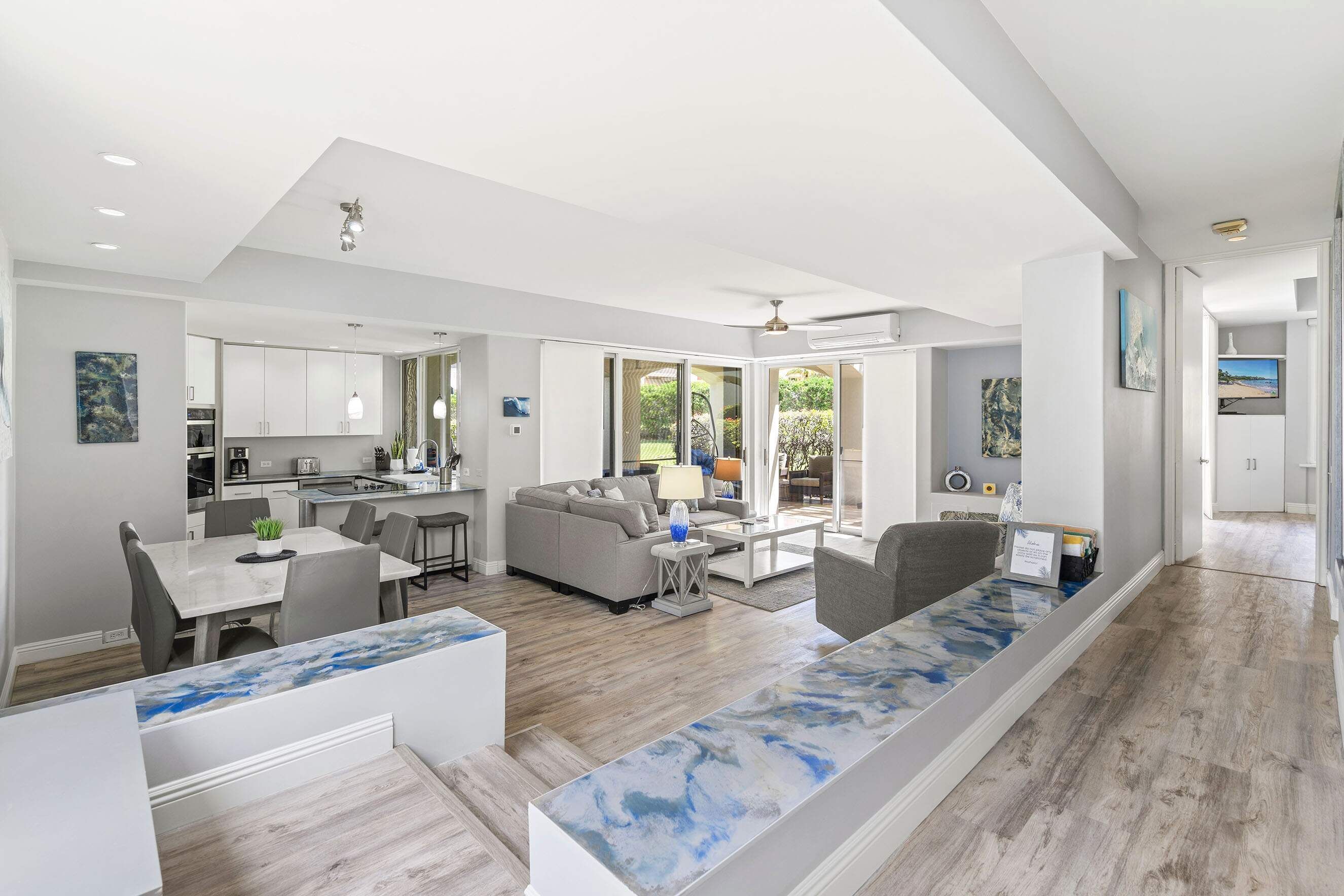 A spacious living area with a kitchen, dining space, and a large window providing a view of the outdoors.