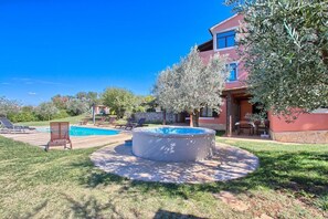 A pool area with a hot tub, lounge chairs, and a stone patio. - Apartments Aldo (16178-A1) - Banjole (Banjole)