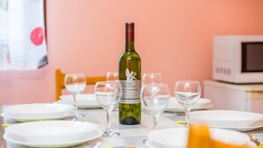 Ein Esstisch mit Geschirr, Weingläsern und Besteck, einschließlich einer Flasche Vina Aguna Wein.
