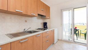 Une cuisine moderne avec des meubles en bois, une cuisinière à gaz et un évier.