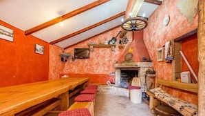 Ein rustikales Interieur mit Holzbänken, einem Kamin und einer Steinwand.
