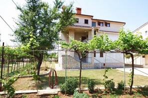 A two-story house with a covered porch and a small staircase leading to the upper floor. - Apartment Ratko (16257-A2) - Medulin (Medulin)