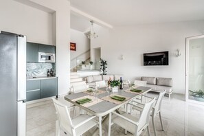 Una cocina moderna con microondas integrado y comedor con mesa lista para cuatro.