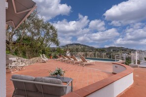 A rooftop terrace with lounge chairs, a pool, and a scenic view of hills. - Modern Sorrento Coast Villa with Private Pool & Terrace (Massa Lubrense)