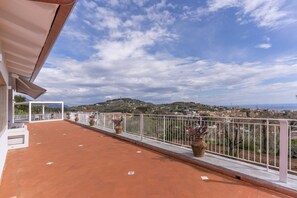 A terrace with terracotta flooring, white railings, and potted plants. - Modern Sorrento Coast Villa with Private Pool & Terrace (Massa Lubrense)