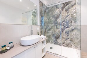 Een douche, een bidet, handdoeken, toiletpapier
