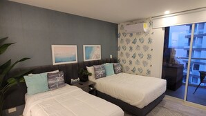 A modern bedroom with two beds, a grey wall, and a patterned rug. - Personal Jacuzzi•Beach •Pool•Personal Concierge (La Boquilla)