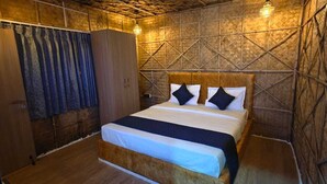 Una habitación con cama, armario de madera y cortina.