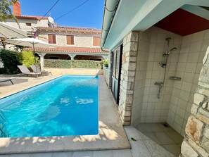 A swimming pool with a stone wall and a shower area. - Apartments Ladonia (16296-A2) - Krnica (Pula) (Krnica (Pula))