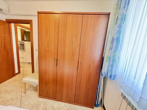 A room with a wardrobe, a bench, and a kitchen area in the background. - Apartments Ladonia (16296-A3) - Krnica (Pula) (Krnica (Pula))