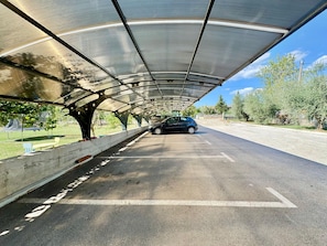 A covered parking area with a car parked under a metal roof structure. - Apartments Ladonia (16296-K1) - Krnica (Pula) (Krnica (Pula))